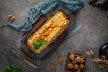 Yukarıdan bakıldığında, geleneksel karamelli yumurta akı pudingi bol bol tatlı şurup serpiştirilmiş ve cam bir tepside taze nane ile süslenmiş bir molotof sergilenmektedir.