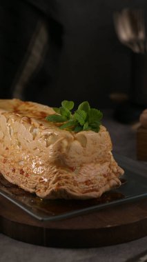Klasik bir molotof tatlısı, zengin bir karamelize kabuk ve narin bir krema, temiz bir tabakta taze nane filizleriyle süslenmiş..