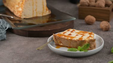 Tek bir porsiyon karamelli molotof pudingi, beyaz yuvarlak bir tabakta, nane şekeri ile süslenmiş,.