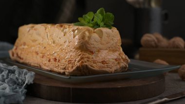 Altın karamelli kremalı tatlı, klasik bir molotof ya da molotof, dikdörtgen bir tabakta taze nane yapraklarıyla süslenmiş, davetkar ve lezzetli.