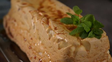 Baştan çıkarıcı bir molotof pudingi, onun altın karamel jölesi, taze yeşil nane yapraklarıyla güzelce süslenmiş açık beze ile zıt..