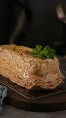 Klasik bir molotof tatlısı, zengin bir karamelize kabuk ve narin bir krema, temiz bir tabakta taze nane filizleriyle süslenmiş..