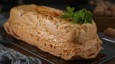 Zarif bir molotof tatlısı, mükemmel karamelize edilmiş krema kabuğu ve zarif bir nane garnitürü, parlak bir tabakta sunuluyor..