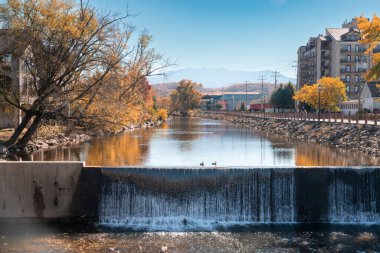 Güvercin Forge, Tennessee - 27 Ekim 2022: Güneşli bir sonbahar gününde Pigeon Forge TN 'nin turistik bölgesinde tarihi Old Mill District manzarası. 