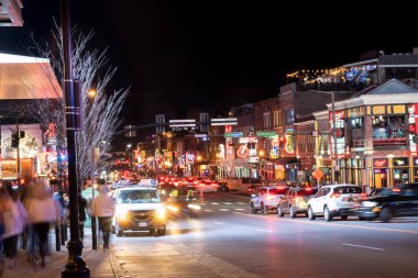 Nashville, Tennesee - January 21, 2023:  Street scene from famous lower Broadway in Nashville Tennessee viewed at night with lights, historic honky-tonks, bars and restaurants.  clipart