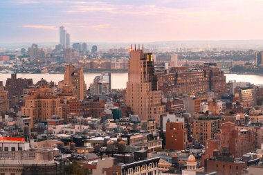 New York City boyunca gün batımı manzarası Hudson Nehri 'ne ve New Jersey' e doğru binalar ve renkli gökyüzü.