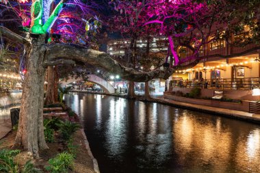 San Antonio Teksas 'taki tarihi sahil yürüyüşünün gece manzarası... Akşamları renkli ışıklar ve kanallarla...
