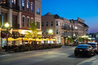 Carmel, Indiana - 25 Temmuz 2024: Midwest banliyö şehri Carmel Indiana 'dan Monon Trail boyunca Sanat ve Tasarım Bölgesi yakınlarındaki bir gece sokak sahnesi. 