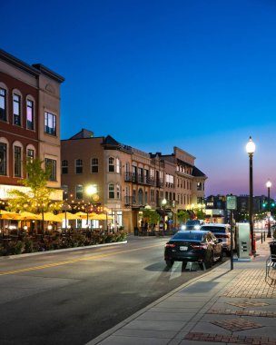Carmel, Indiana - 25 Temmuz 2024: Midwest banliyö şehri Carmel Indiana 'dan Monon Trail boyunca Sanat ve Tasarım Bölgesi yakınlarındaki bir gece sokak sahnesi. 
