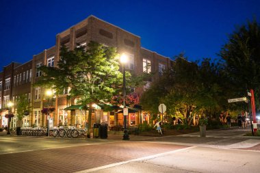Carmel, Indiana - 25 Temmuz 2024: Midwest banliyö şehri Carmel Indiana 'dan Monon Trail boyunca Sanat ve Tasarım Bölgesi yakınlarındaki bir gece sokak sahnesi. 
