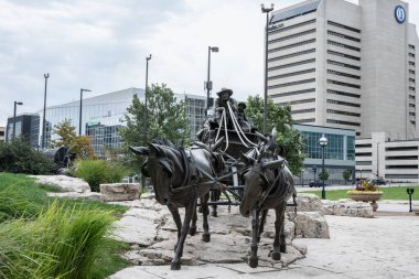 Omaha, Nebraska - 21 Ağustos 2024: Omaha Nebraska şehir merkezinden tarihi olayları resmeden bronz heykellerle Pioneer Courage Park 'ın görüntüsü