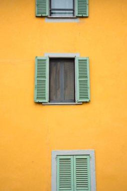 Pencereleri panjurlu eski sarı bina cephesi
