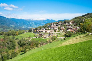 Geleneksel kasaba mimarisi ile İtalyan Alpleri Dolomitleri manzarası. 