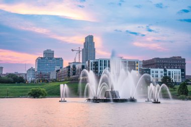 Günbatımında Omaha Nebraska 'nın ufuk çizgisi manzarası Amerika' nın Heartland 'ından Riverside Park' ta göl manzaralı..