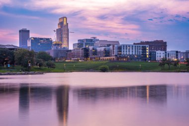 Günbatımında Omaha Nebraska 'nın ufuk çizgisi manzarası Amerika' nın Heartland 'ından Riverside Park' ta göl manzaralı..