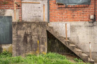 Terk edilmiş tuğla ve çimentoyla terk edilmiş binanın dış duvarı.
