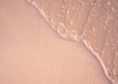 Kum üzerinde köpüklü deniz suyuyla detaylı plaj dokusu