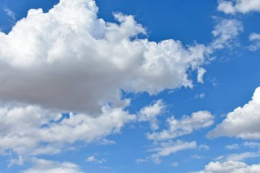 Arka plan tasarımı için mavi gökyüzünde yüzen dramatik beyaz kümülüs bulutları, yatay biçim.