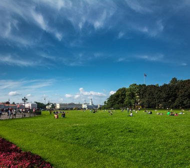 ST. PETERSBURG, RUSSIA - JULY 11, 2016: Tourists rest in the park on the banks of the Neva River, St. Petersburg, Russia