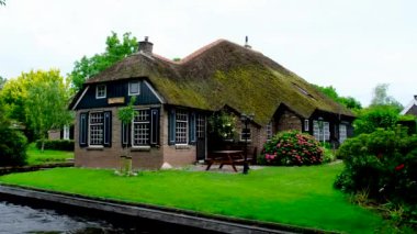 Hollanda 'nın Giethoorn köyündeki bir kanalda geleneksel kıyı evi..