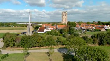 Hollanda 'nın güneyindeki Goeree-Overflakkee adasındaki Goedereede Kulesi ve De Windvang değirmeninin hava manzarası..