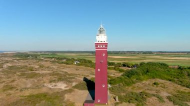 Hollanda 'nın güneyindeki Ouddorp Sahili' ndeki Westhoofd Deniz Feneri 'nin 4K hava görüntüsü..