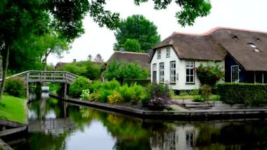 Hollanda 'nın Giethoorn köyündeki bir kanalda geleneksel Hollanda rıhtım evi..