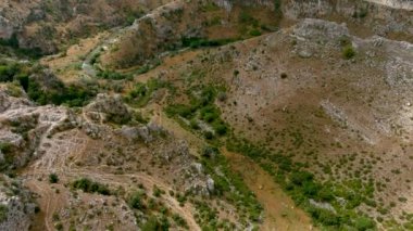 Matera, Güney İtalya 'daki kayalık tepelerin ve Gravina nehrinin havadan görünüşü.