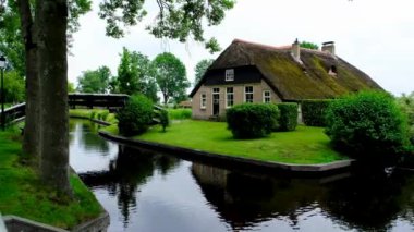 Hollanda 'nın Giethoorn köyündeki bir kanalda geleneksel kıyı evi..