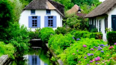 Hollanda 'nın Giethoorn köyündeki bir kanalda geleneksel kıyı evi..
