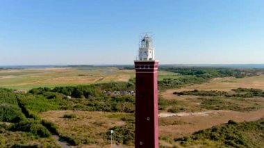 Hollanda 'nın güneyindeki Ouddorp Sahili' ndeki Westhoofd Deniz Feneri 'nin 4K hava görüntüsü..