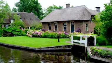 Hollanda 'nın Giethoorn köyündeki bir kanalda geleneksel Hollanda rıhtım evi..