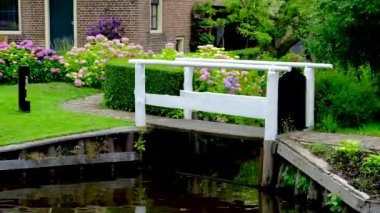 Hollanda 'nın Giethoorn köyündeki bir kanalda küçük bir köprü..