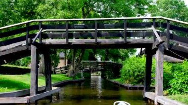 Turistler Hollanda 'nın Giethoorn kasabasındaki bir kanalda tekne turunun keyfini çıkarıyorlar..