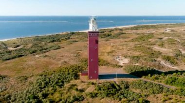Hollanda 'nın güneyindeki Ouddorp Sahili' ndeki Westhoofd Deniz Feneri 'nin 4K hava görüntüsü..