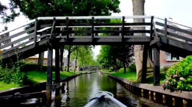 Turistler Hollanda 'nın Giethoorn kasabasındaki bir kanalda tekne turunun keyfini çıkarıyorlar..