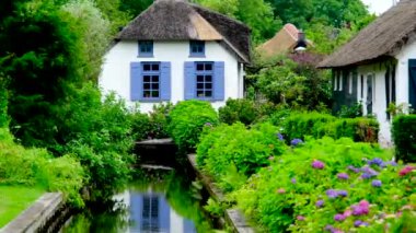 Hollanda 'nın Giethoorn köyündeki bir kanalda geleneksel kıyı evi..