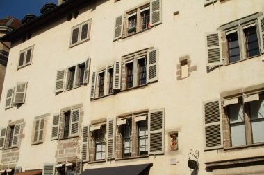 Cenevre, İsviçre 'deki eski ahşap panjurlu eski beyaz duvar desenli eski çok katlı ev cephesi..