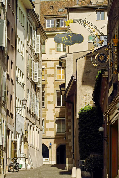 Fragment of a street in the old center of Geneva with old houses exteriors and windows with old wooden shutters pattern. Geneva, Switzerland.