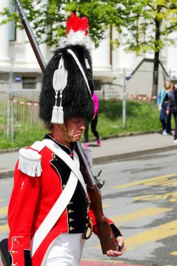 GENEVA; SWITZERLAND-May 04, 2024: Soldier with musket in the Historical Militia of Leontica uniform take part in the street parade Old Grenadiers March, Vieux Grenadiers society 275-years anniversary, May 04, 2024 clipart