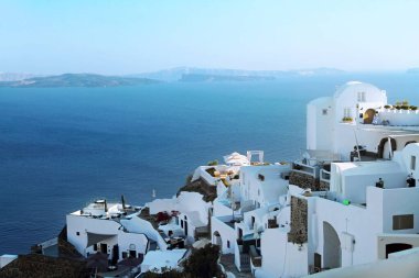 Santorini volkan kalderasının manzarası. Oia 'daki dağ yamacında geleneksel beyaz evler mavi denizin arka planına karşı. Santorini Adası, Yunanistan