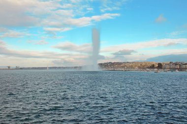 Cenevre Çeşmesi manzaralı. Cenevre Gölü 'ndeki Jet D' eau. Şehir manzaralı ve dağ manzaralı. Cenevre İsviçre.