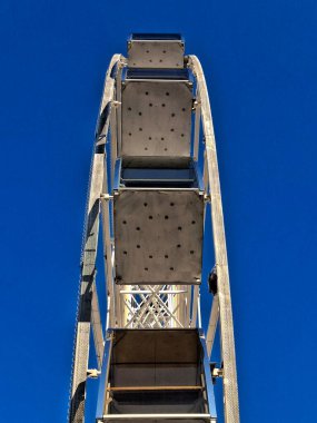 Mavi bir arka planda kocaman bir dönme dolap.