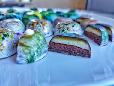 Handmade chocolate bonbons in colorful glaze with assorted fillings  unwrapped artisan sweets