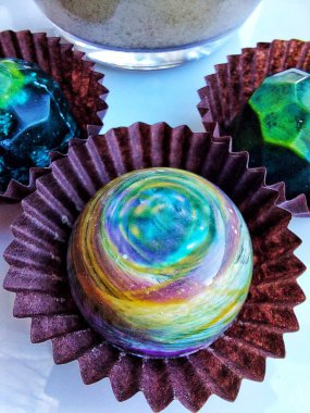 Handmade chocolate bonbons in colorful glaze with assorted fillings  unwrapped artisan sweets