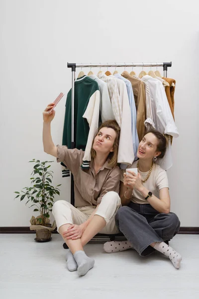 服装组织的概念 两个女性朋友在衣架附近自拍 — 图库照片
