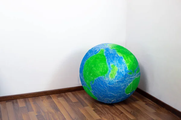 stock image Eco problem. Planet earth in the corner of the room. Surrealism.