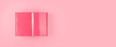 Arka planda, fotokopi alanı olan açık pembe bir kitap. Pankart.