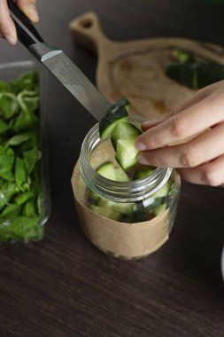 Kadın nohut ve sebzeli kavanozda salata yapıyor. Sağlıklı yemek pişirmek..