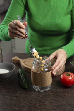 Kavanozda nohutlu salata yapan kadın. Sağlıklı vejetaryen yemekleri pişirmek..